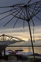 CAMBODIA, Siem Reap. Shade umbrellas frame at beach at Western Baray, sunset