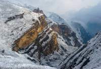 NEPAL, Dolpo. Fresh snow on cliffs on lower slopes of Crystal Mountain, sunrise.