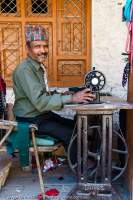 NEPAL, Dolpo. Street-side tailor in market village of Dunai.