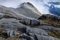 NEW ZEALAND, Fiordland National Park. Tarn & granite slabs, Mt Solitary, Dark Cloud Range.