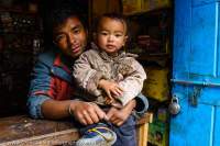NEPAL, Mugu. Shop-keeper and young son.