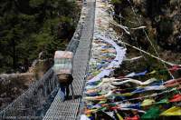 NEPAL. Sagamartha National Park. Suspension bridge over Dudh Kosi below Namche Bazaar, with Buddhist prayer flags.