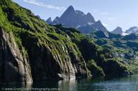 NORWAY, Nordland. Lofoten Islands, Austvagoy. Trolltinden peak towers above glaciated gneiss ridges in Trollfjord.