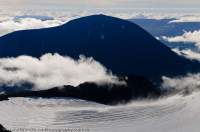 NORWAY, Oppland, Jotunheimen National Park. Besshoe peak and clearing cloud over glacier (with crevasses), from Surtningssue (2366m).