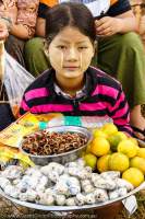 Girl selling quail eggs and fruit at 2014 fire (hot air) balloon festival in Taunggyi, part of full-moon celebrations during Tazaungmon (Tazaungdaing).