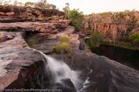 AUSTRALIA, Western Australia, West Kimberley. Waterfall cascades over sandstone strata, Bachsten Creek, dawn.