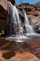 AUSTRALIA, Western Australia, West Kimberley. Shower in waterfall in tributary stream, Charnley River gorge.