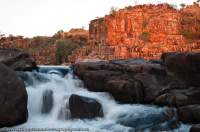 AUSTRALIA, Western Australia, West Kimberley. Cascade below sandstone cliffs, Charnley River gorge, sunset.