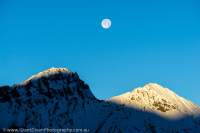 NEPAL, Dolpo. Moon setting behind snow peaks, Chyandi Khola valley.