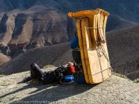 NEPAL, Dolpo. Expedition porter resting in shade of plastic dining tables.