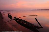 LAOS, Champasak. Heua phai (rowboat) moored beside Mekong River, dawn.