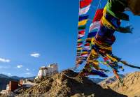 Buddhist prayer flags and Tsemo Gompa, monastery/fort on hilltop overlooking Leh city. Sunset.