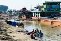 Clothes washing beside unloading boats on bank of Ayeyarwady (Irrawaddy) River.
