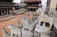 NEPAL. Bhaktapur, Kathmandu valley. Stone guardians flanking stairway at 17th century Siddhi Lakshmi Temple, Vatsala Durga Temple beyond, Durbar Square.