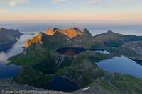 NORWAY, Nordland. Lofoten Islands, Moskenesoy. Glacial lakes & Reine fjord, from summit of Hermannsdalstinden (1029m, highest in west Lofoten); midnight sunset
